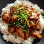 Bowl of Japanese Butadon with pork, rice, and garnishes