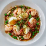 Plate of shrimp with lobster sauce garnished with herbs