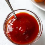 Homemade sweet and sour sauce in a bowl with ingredients
