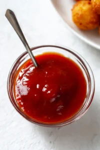 Homemade sweet and sour sauce in a bowl with ingredients