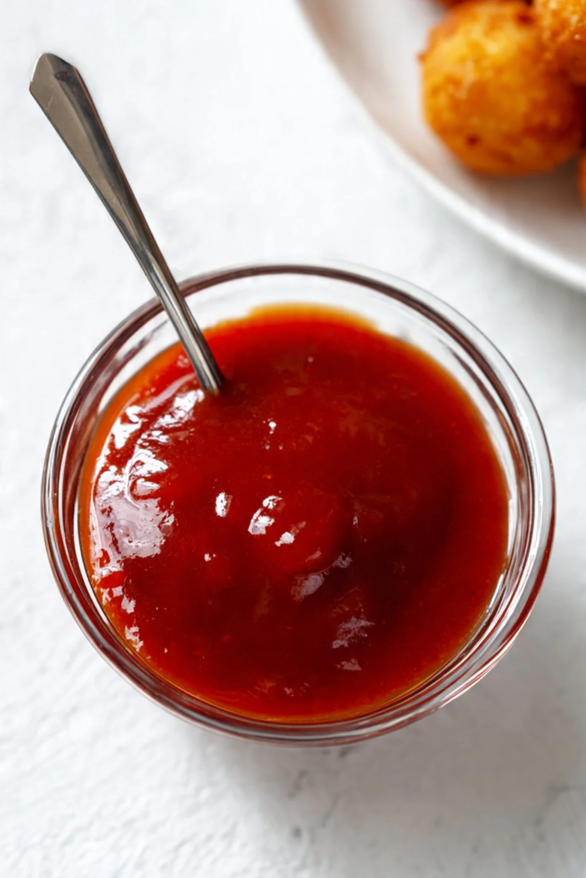 Homemade sweet and sour sauce in a bowl with ingredients